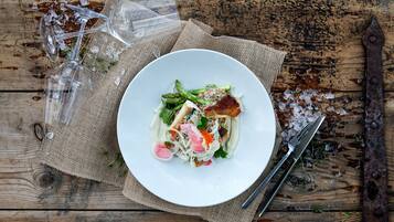 Un plato blanco con una ensalada sobre una mesa de madera rústica.