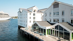 A waterfront hotel with a dock extending into the water, featuring outdoor seating and large windows. - Thon Hotel Kristiansund (Kristiansund)