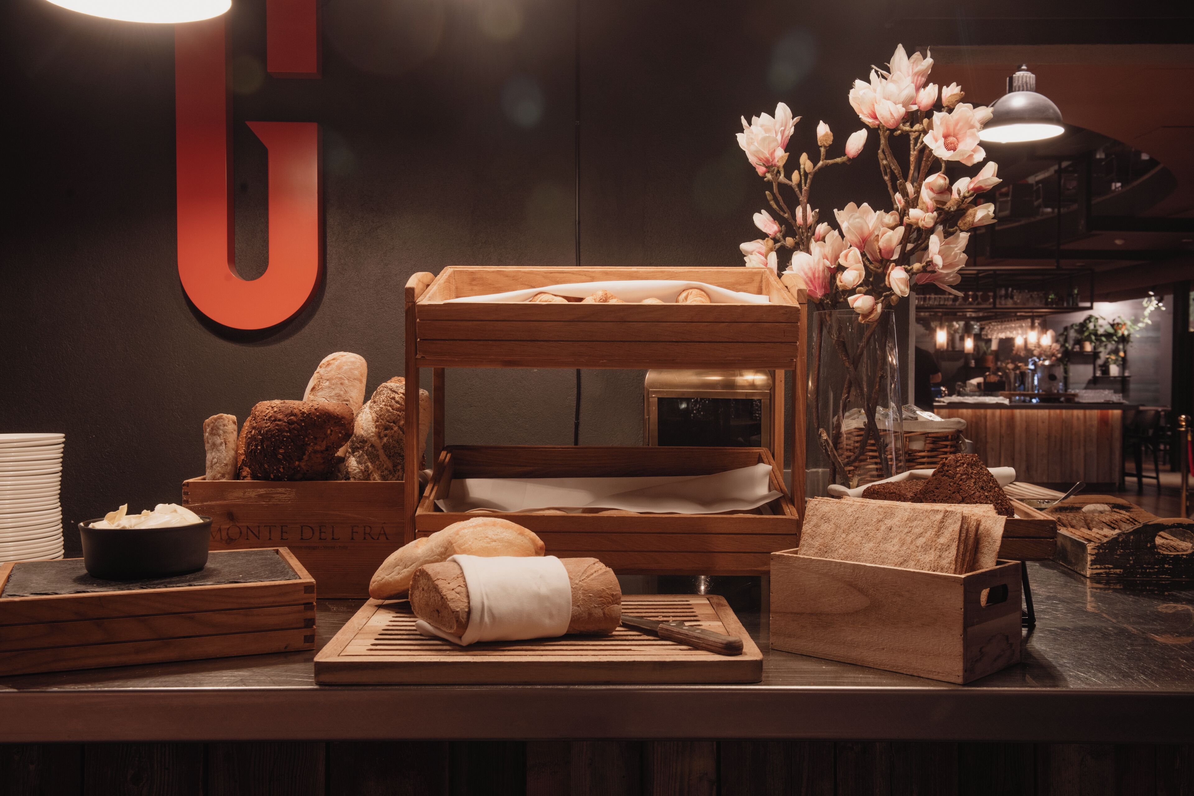 A bakery display with bread, pastries, and flowers.
