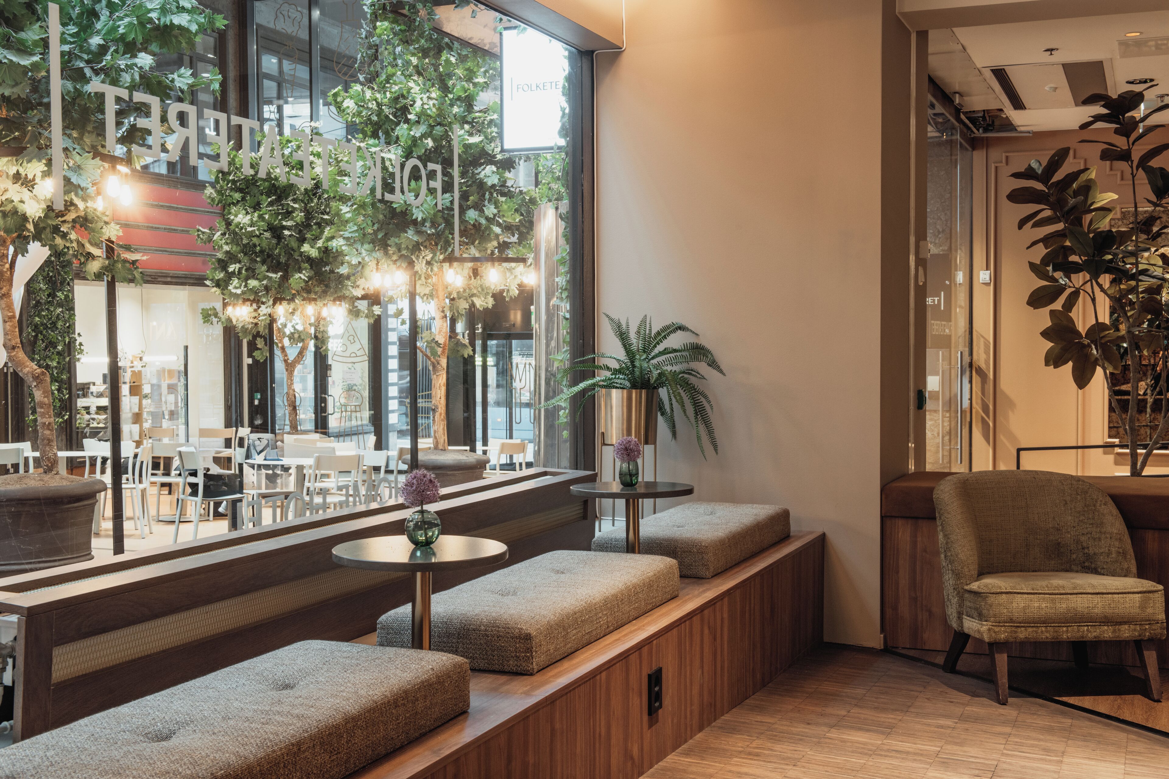 A modern interior with seating areas, a wooden bench, and a potted plant.