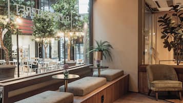 A modern interior with seating areas, a wooden bench, and a potted plant.