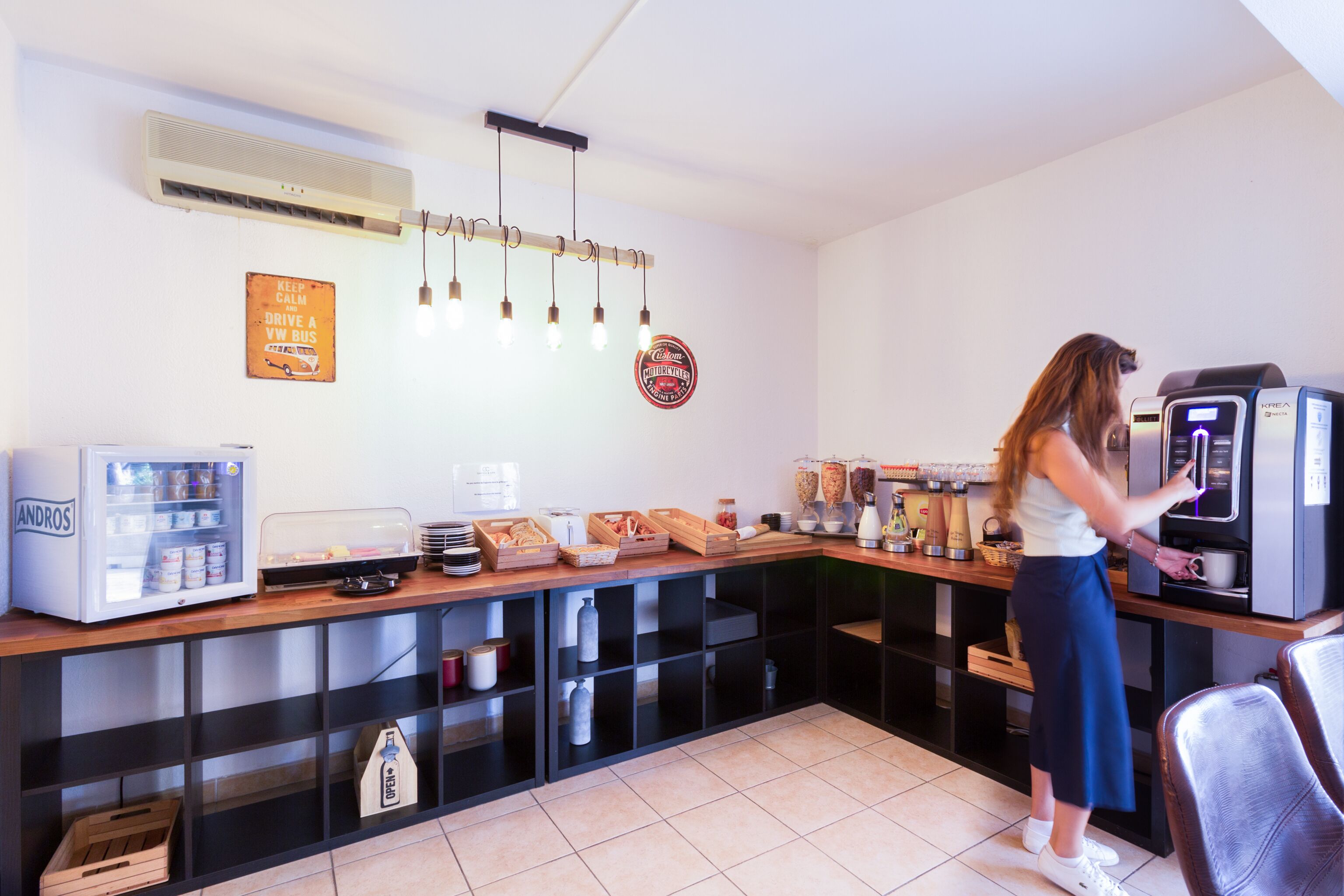 Une petite cuisine équipée d’une machine à café, d’un réfrigérateur et d’un four à micro-ondes.