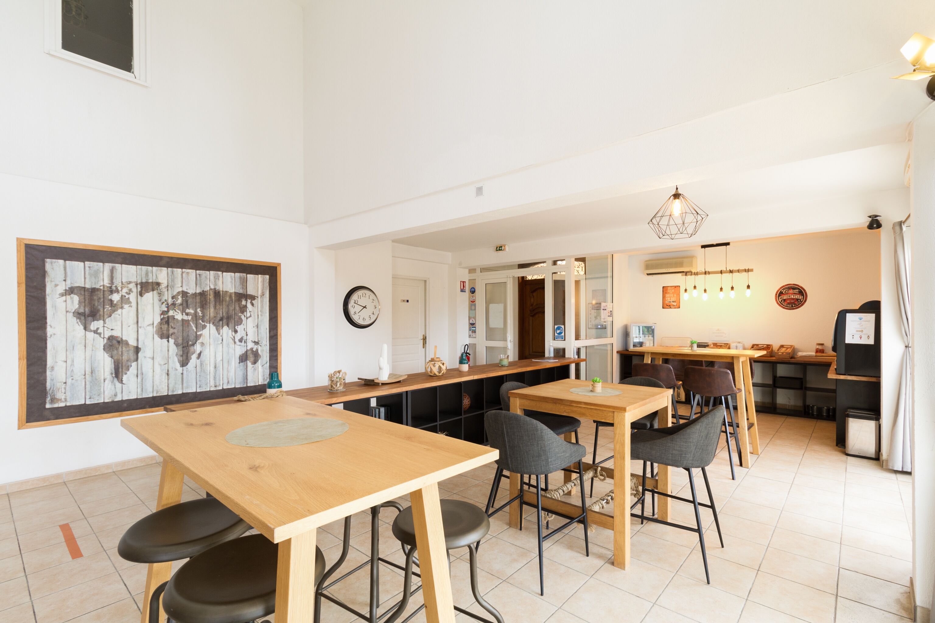 Una cocina moderna con encimeras de madera, un comedor con mesa y sillas de madera, y una obra de arte con un mapa del mundo en la pared.