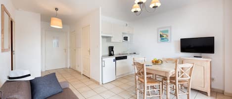 A modern apartment with a kitchen, dining area, and living room.
