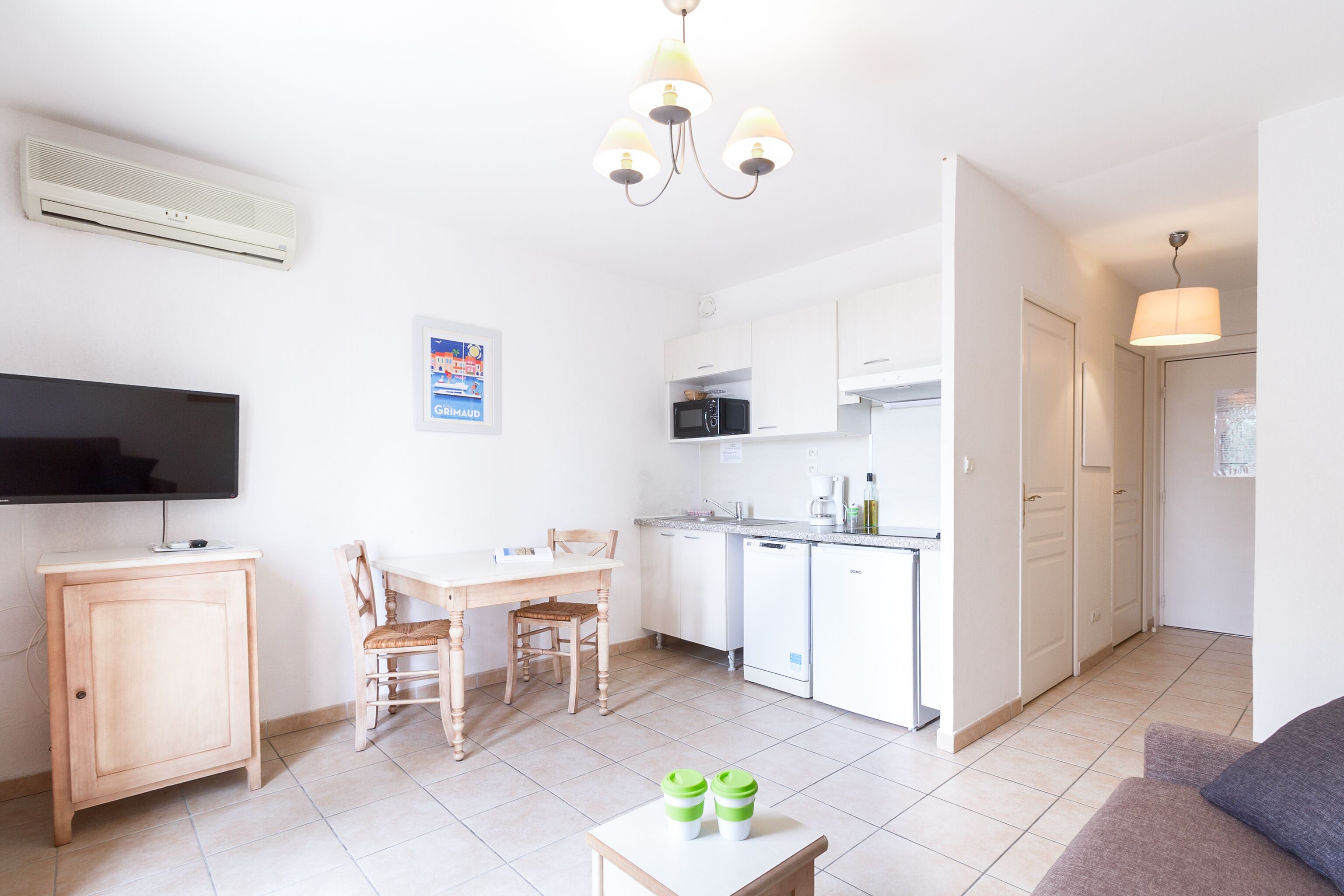 A modern apartment with a dining area, kitchen, and living space.