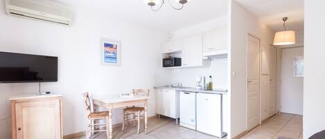 A modern apartment with a dining area, kitchen, and living space.