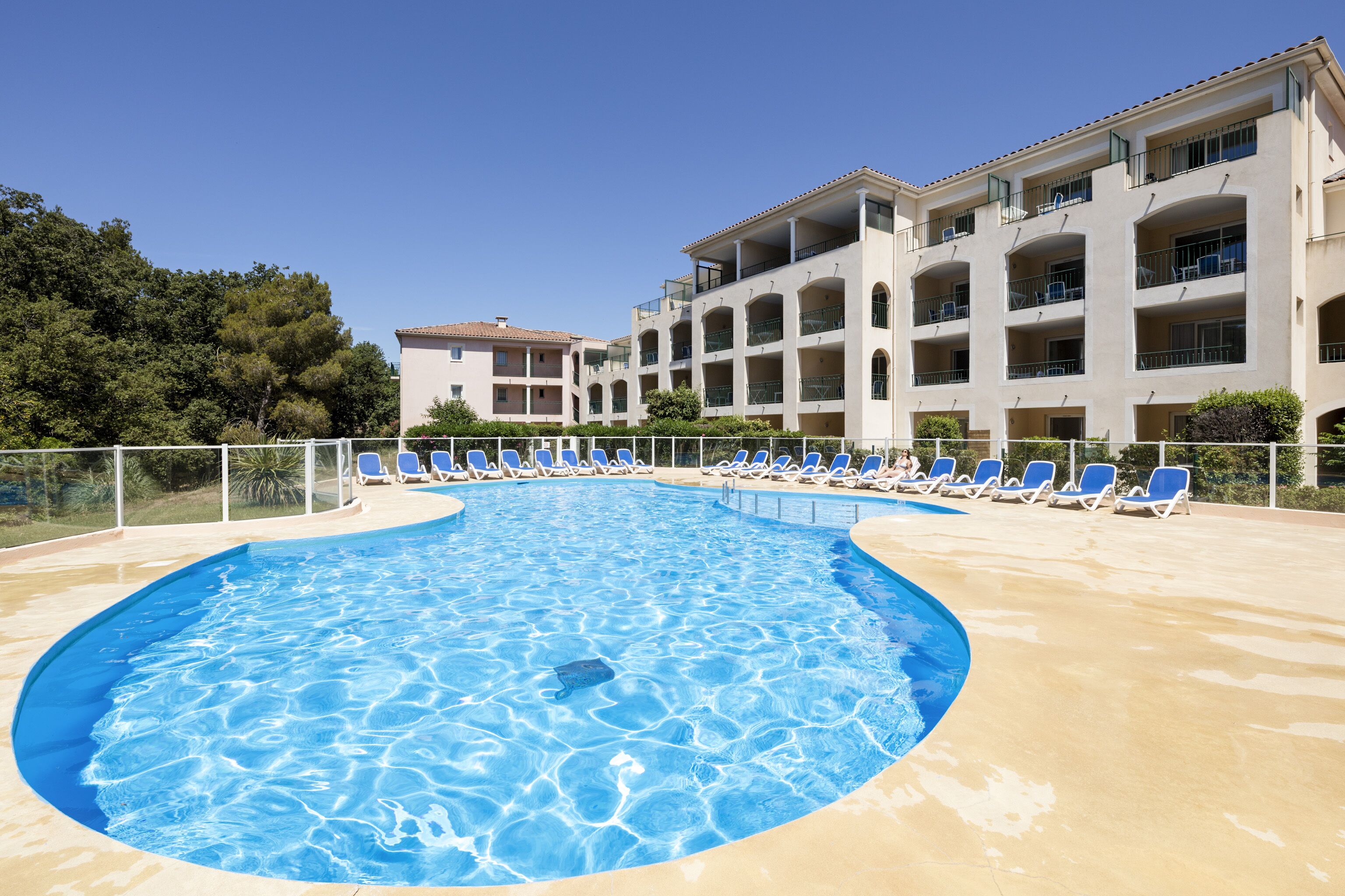Una piscina al aire libre de temporada, sombrillas, tumbonas
