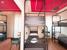 Un dormitorio con literas, un escritorio y una silla.