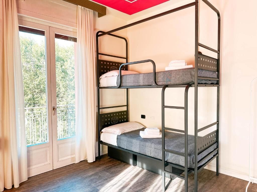 A bunk bed room with a view of trees through a glass door.
