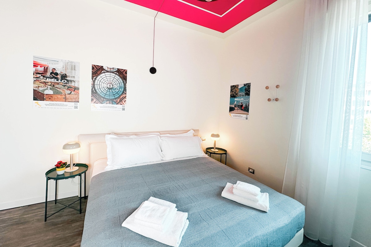 Un dormitorio moderno con cama, dos mesitas de noche y una ventana con cortinas.