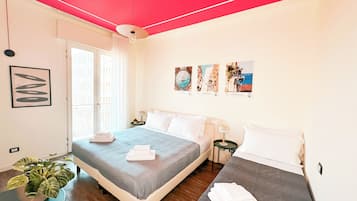 Una camera d'albergo con un letto, un comodino, una lampada, una pianta in vaso e una finestra con tende.