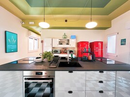 Een moderne keuken met een centraal eiland, roestvrijstalen apparatuur en een keukenkastje met een geruit ontwerp.