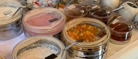 A variety of food items in transparent containers with spoons, including what appears to be oatmeal, yogurt, and a vegetable mix.