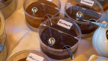 Variedad de alimentos en recipientes transparentes con etiquetas, incluyendo frascos de diferentes salsas y un tazón de galletas.