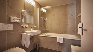 Un baño moderno con inodoro, lavamanos y bañera.