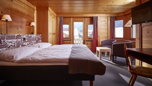 Une pièce de cabane en bois comprenant un lit, deux chaises, une table et un téléviseur.