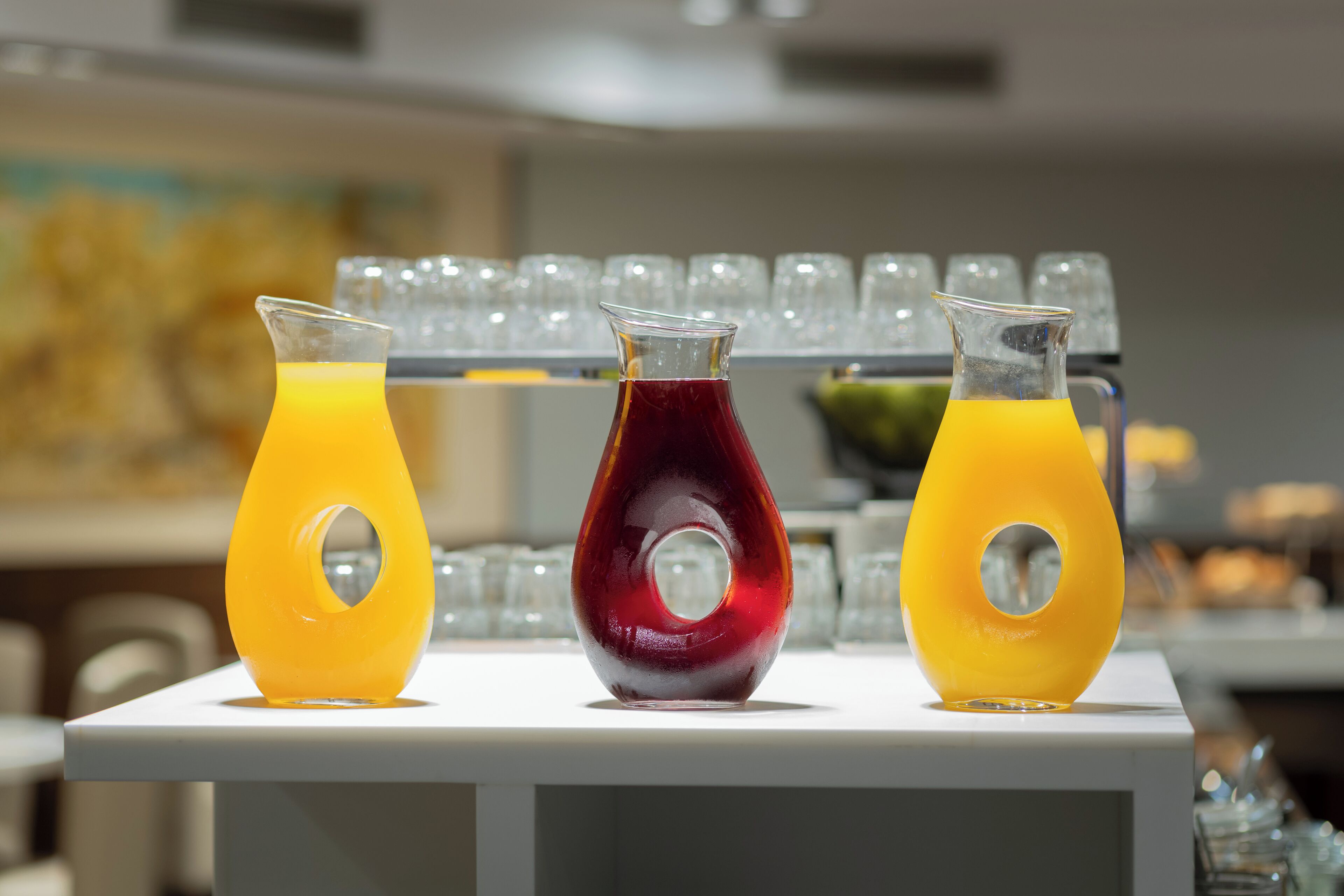 Three glass bottles with a unique design, placed on a white surface.