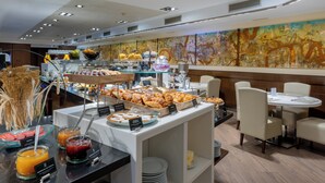 A breakfast buffet with various food items and a seating area with tables and chairs.