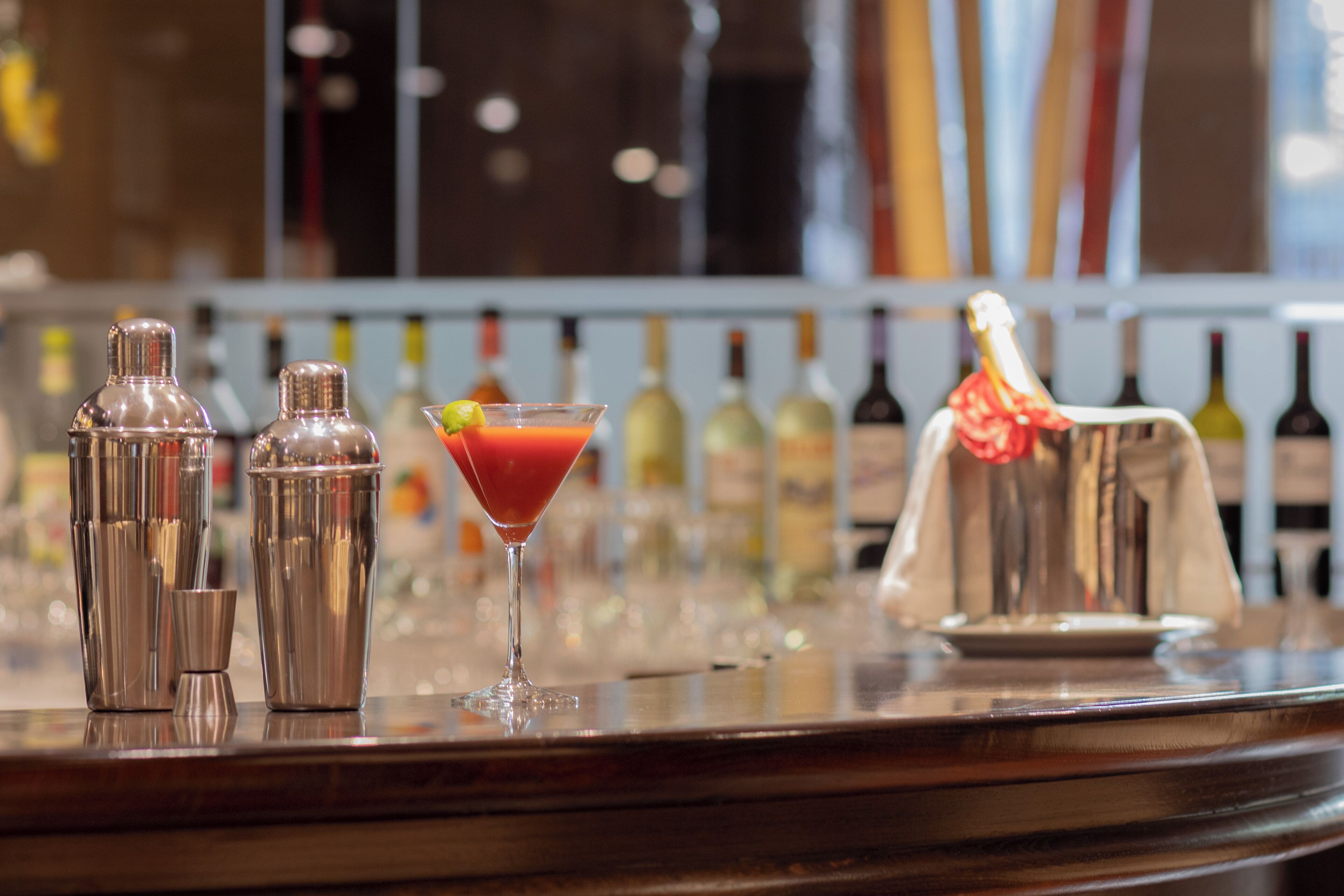 Un coin bar avec un verre à martini et des shakers à cocktails sur le comptoir.