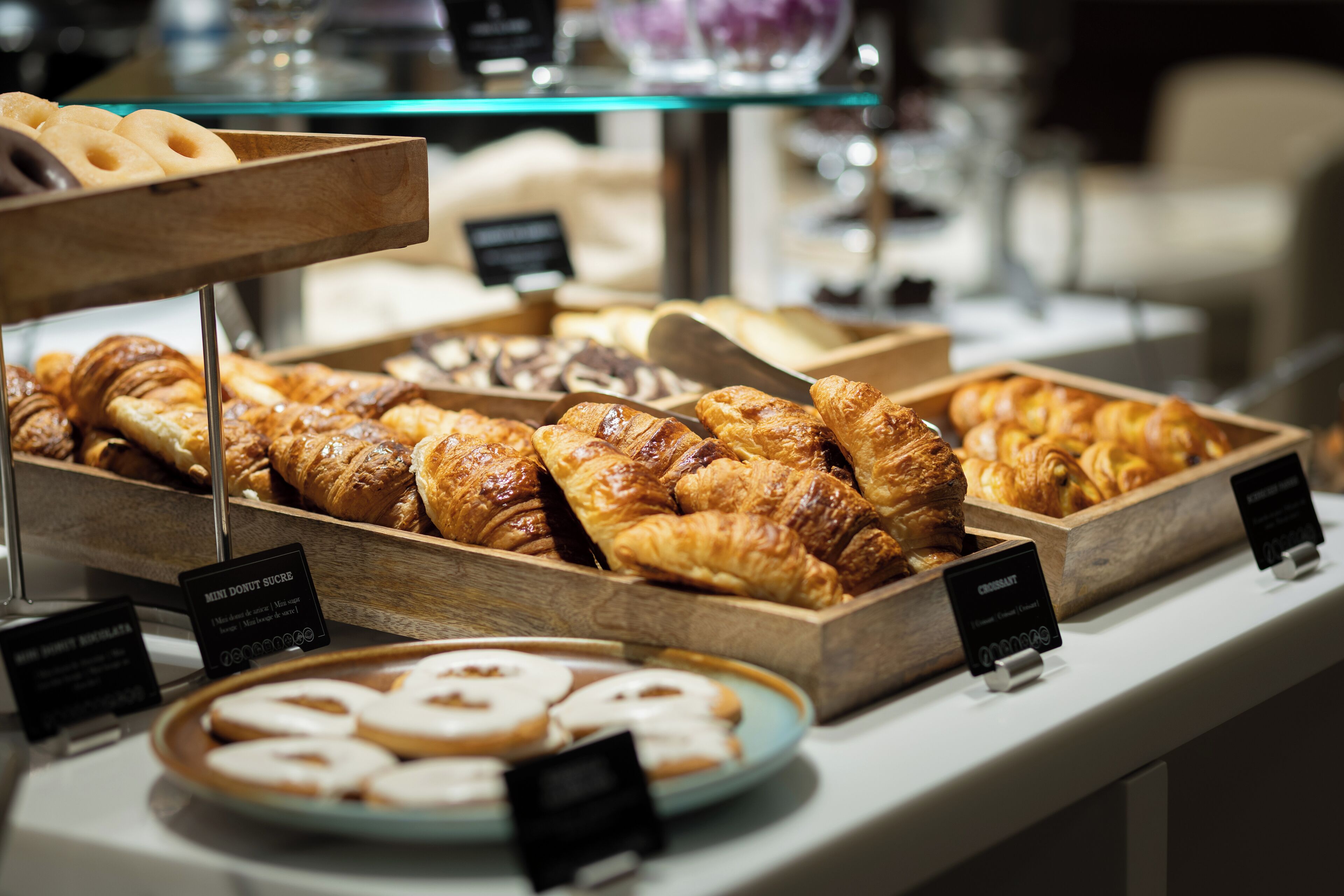 A display of assorted pastries and donuts in a bakery section of a hotel.