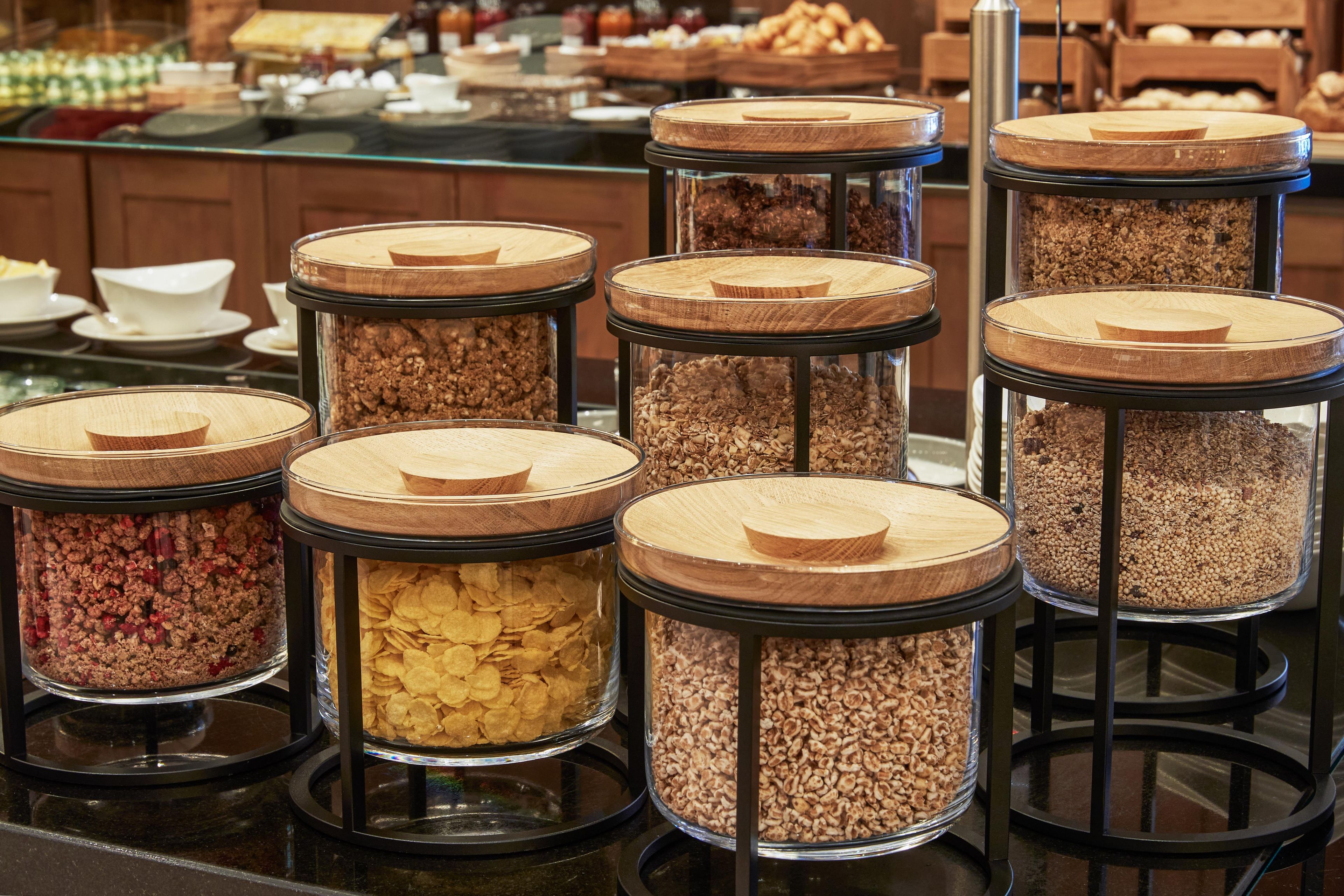 A buffet with multiple glass jars containing various food items.
