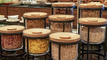 Un bufé con varios recipientes de vidrio repletos de diversos alimentos.