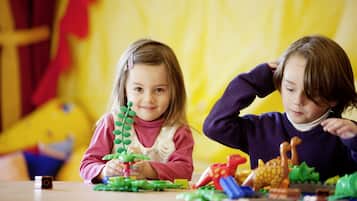 Dos niños jugando con juguetes en una mesa.