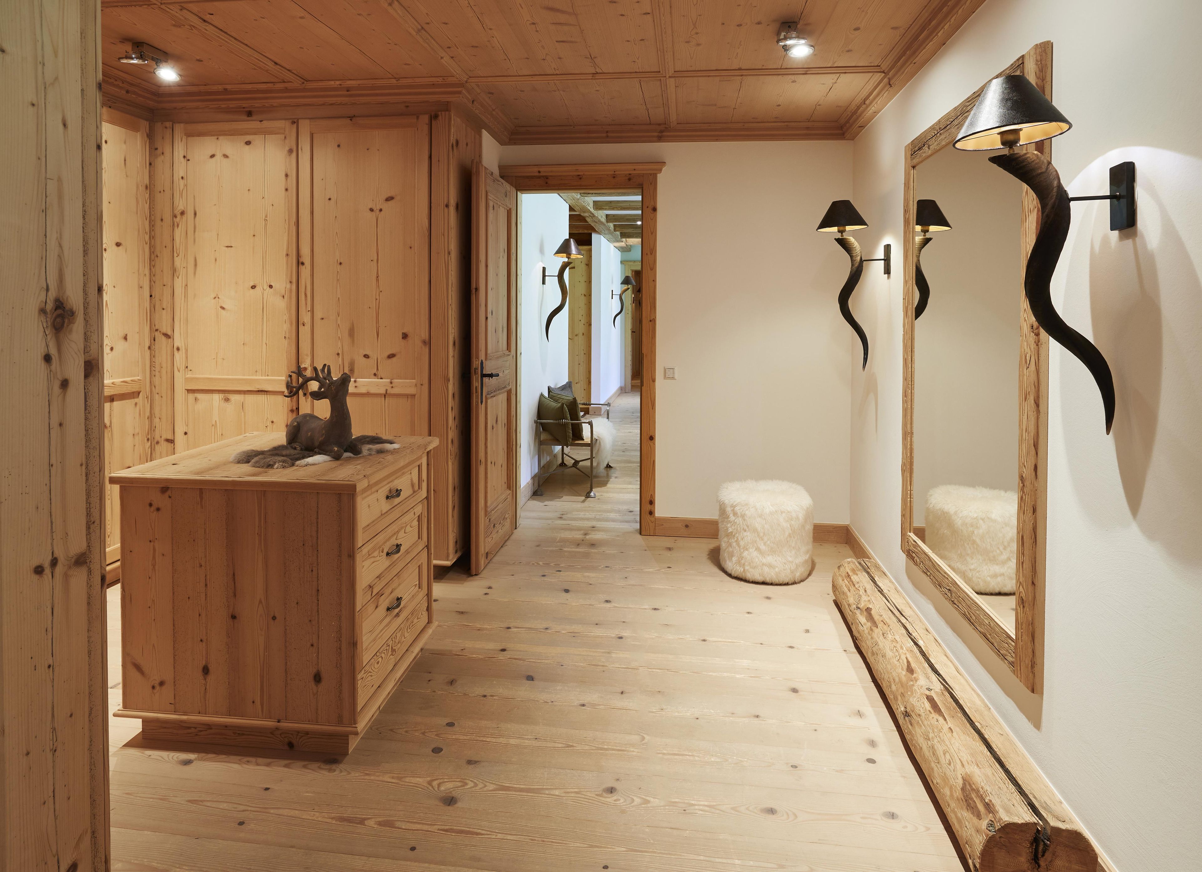 Un interior de madera con un aparador, un espejo y una lámpara.