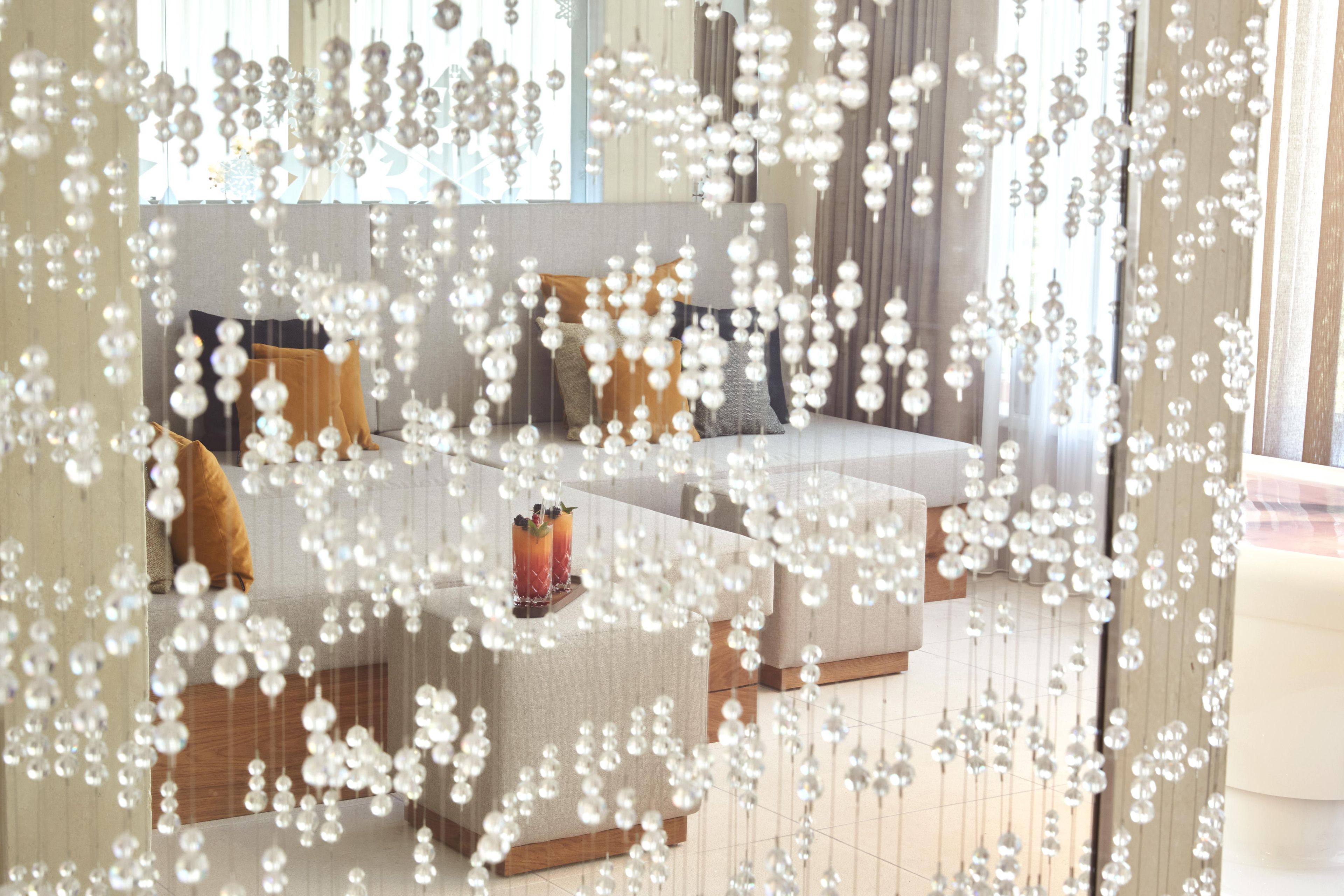 Uma sala de estar moderna com sofá, mesa de centro e luminárias decorativas pendentes.