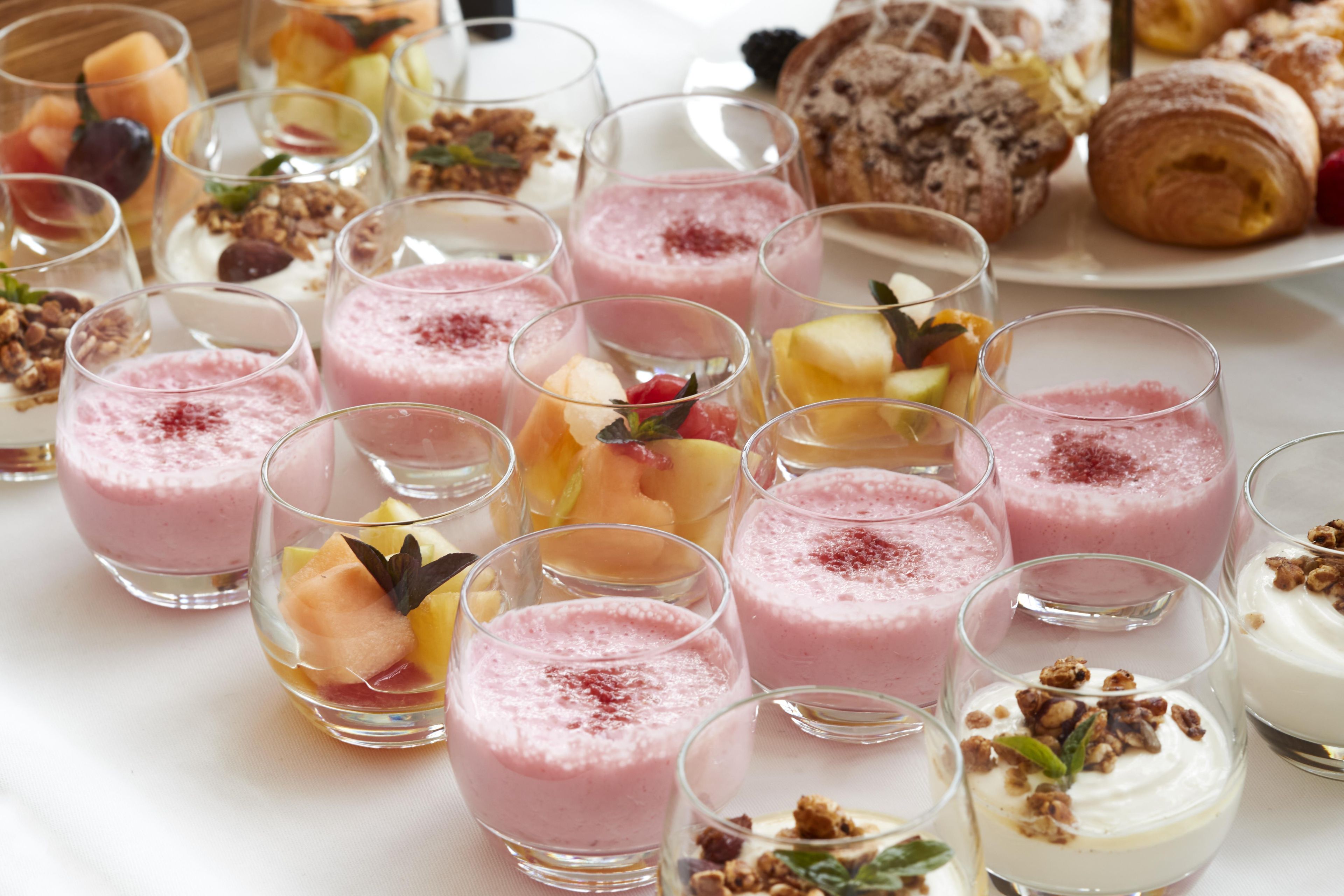 A variety of fruit smoothies and desserts on a table.