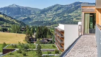 A modern building with a balcony overlooking a mountainous landscape.