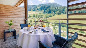 A dining area with a table set for breakfast, overlooking a mountainous landscape. - Kempinski Hotel Das Tirol (Jochberg)