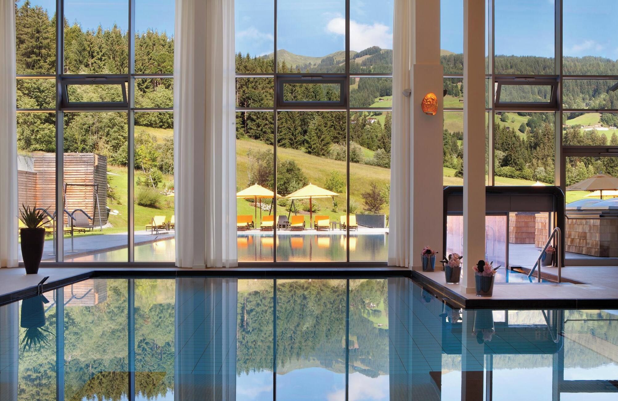 A pool area with clear views of a mountainous landscape through large windows.