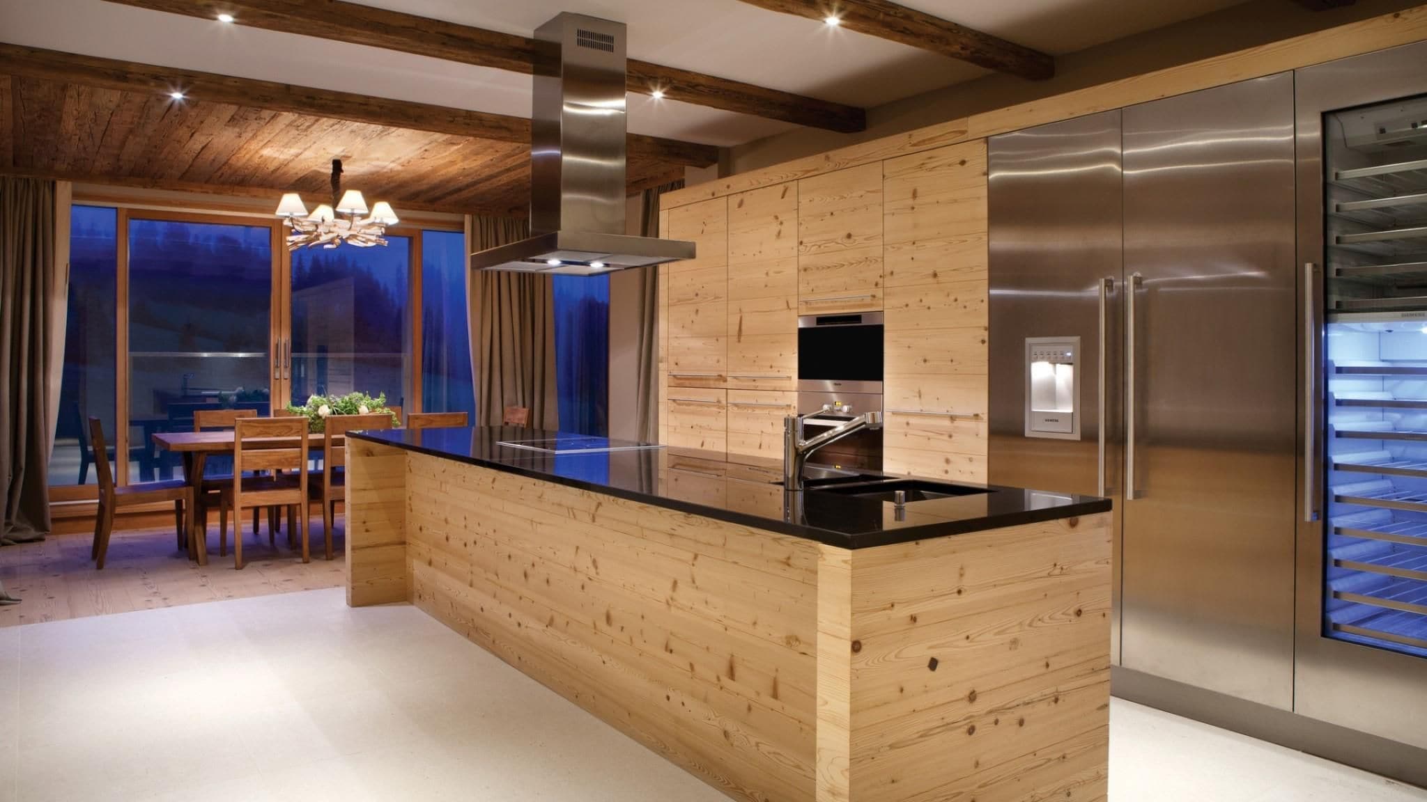 Una cocina moderna con una isla de madera, electrodomésticos de acero inoxidable y un comedor con vistas.