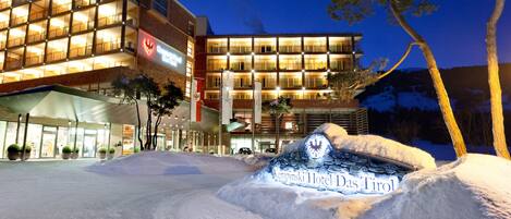 A hotel with a modern design, featuring multiple balconies and a prominent entrance.