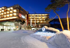 Un hotel de diseño moderno, con varios balcones y una entrada destacada.