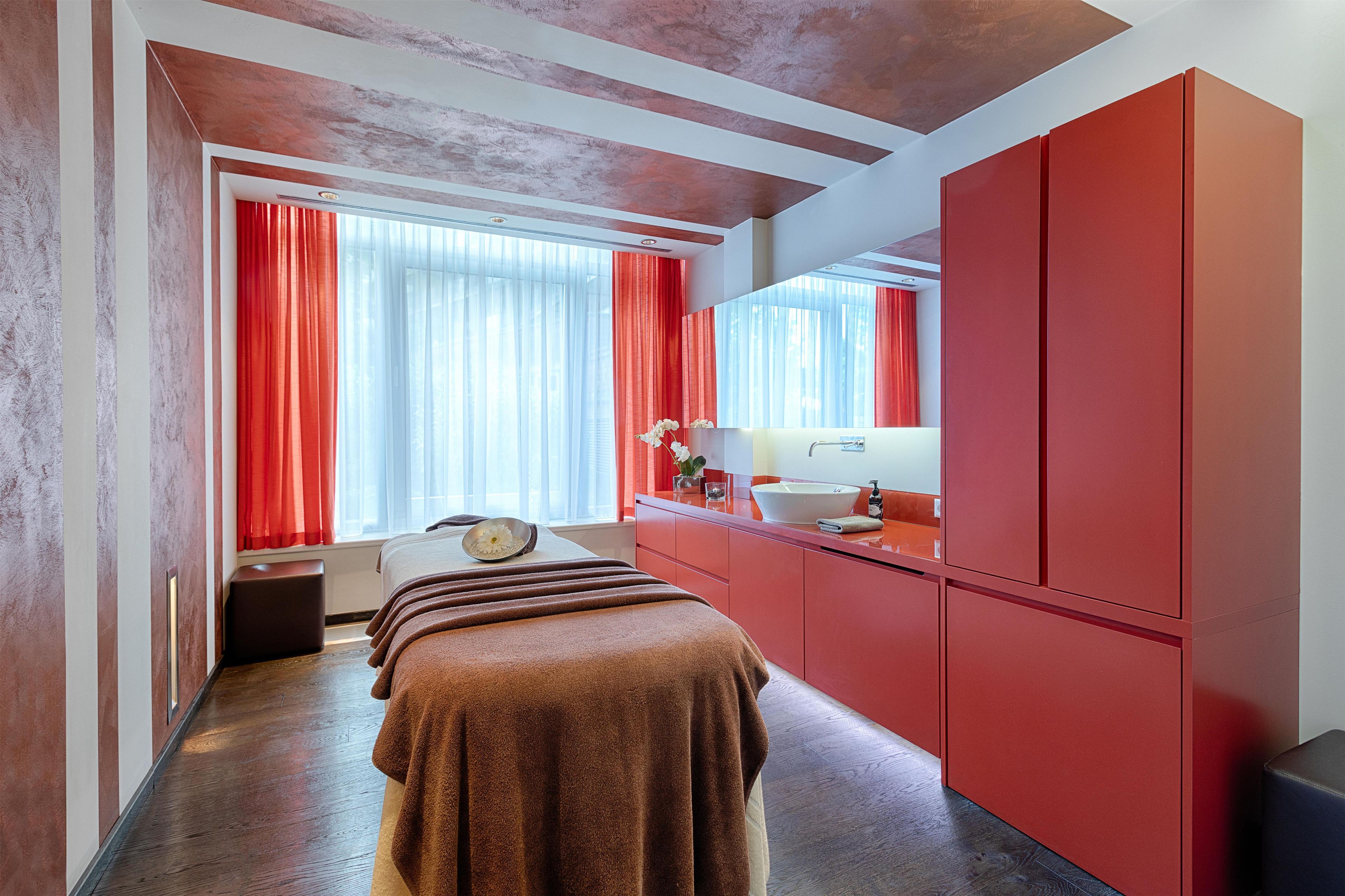 Ein modernes Badezimmer mit einem roten Waschtisch, einem großen Spiegel und einem Handtuchhalter.
