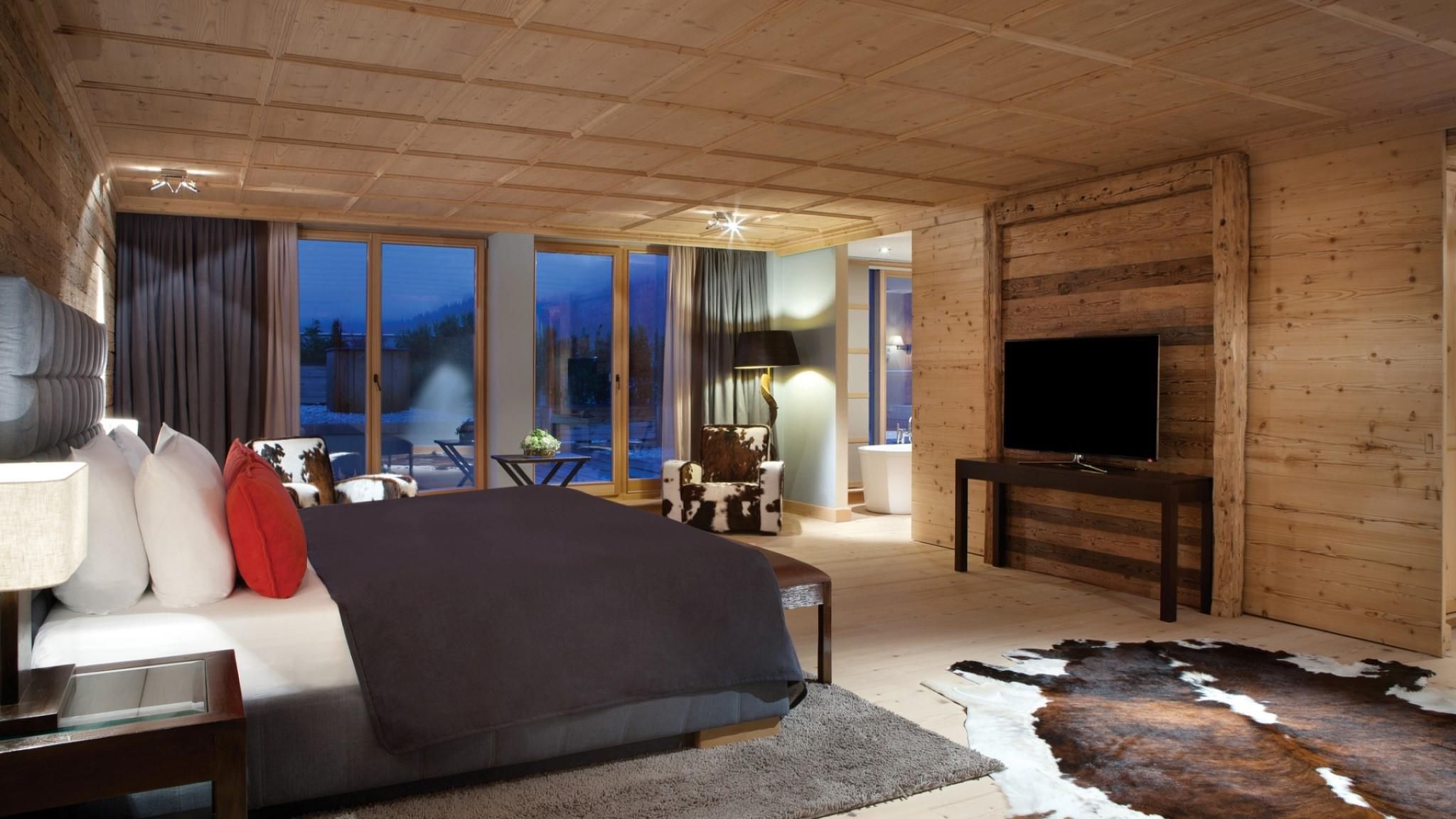 Un dormitorio moderno con una cama grande, un televisor y vistas al exterior.
