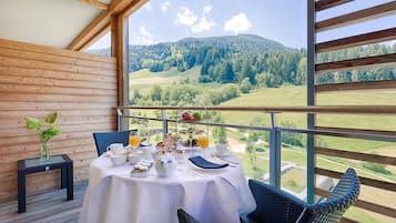 A dining area with a table set for breakfast, overlooking a mountainous landscape.