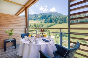 Un comedor con una mesa dispuesta para el desayuno, con vistas a un paisaje montañoso.