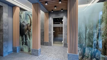 Un moderno vestíbulo con piso de piedra, columnas de madera y un mural grande en la pared.
