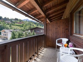 Un balcón de madera con vistas a un paisaje montañoso.