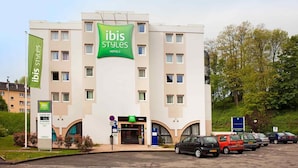Un edificio de hotel con un llamativo letrero verde y blanco que dice 'ibis Styles Hotels'.