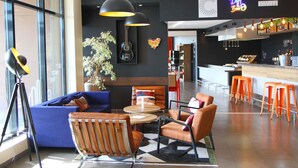 Un área de bar moderna con un letrero de neón, asientos y una barra.