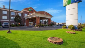 Un bâtiment Holiday Inn Express & Suites doté d’une entrée abritée, d’un parking et d’une pelouse bien entretenue.