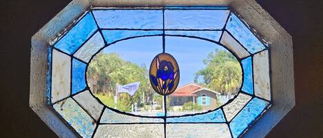 Une vitre décorative composée de vitraux, ornée d’un motif géométrique et d’un élément ovale central.