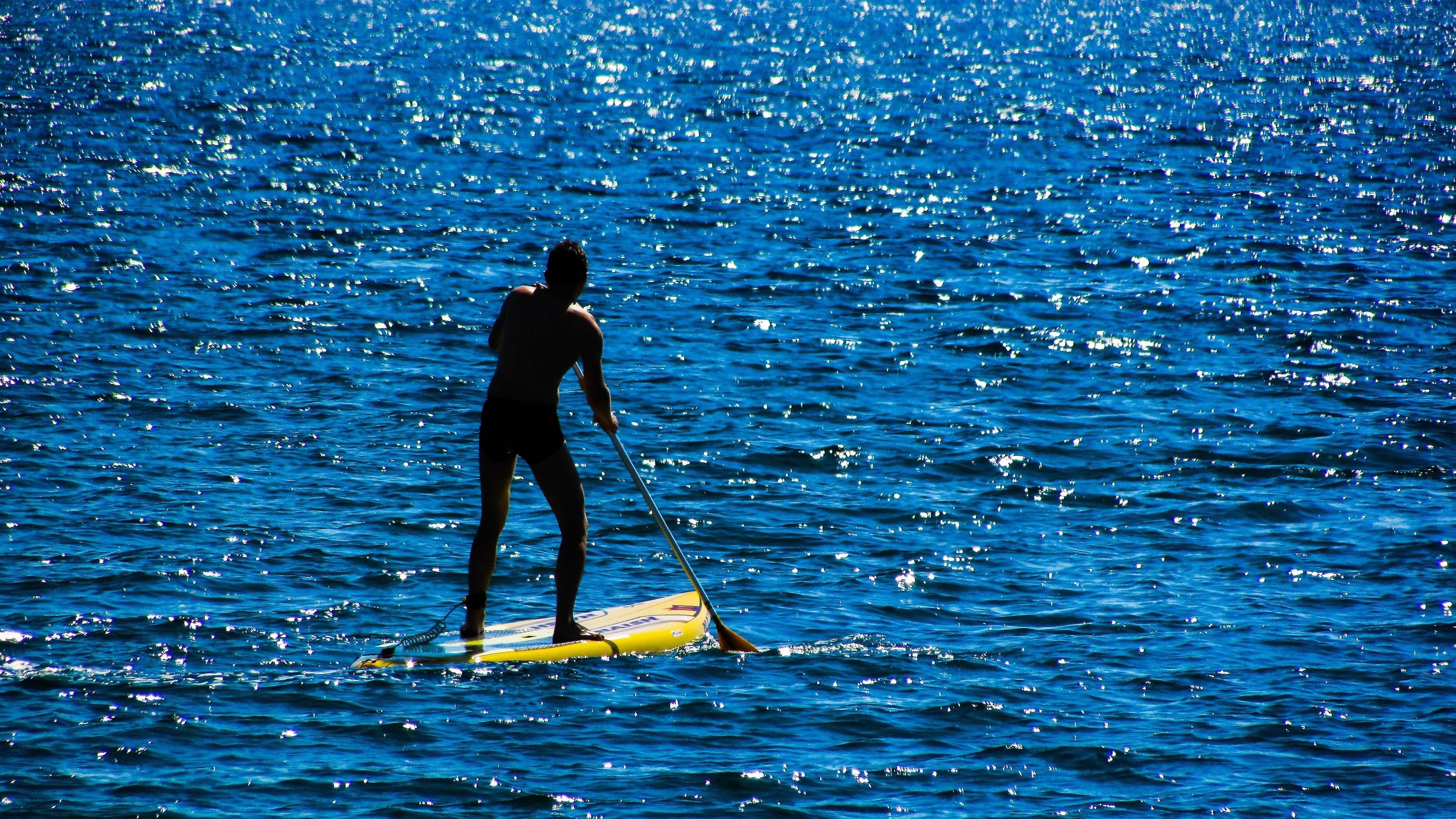 A person paddleboarding on a body of water.