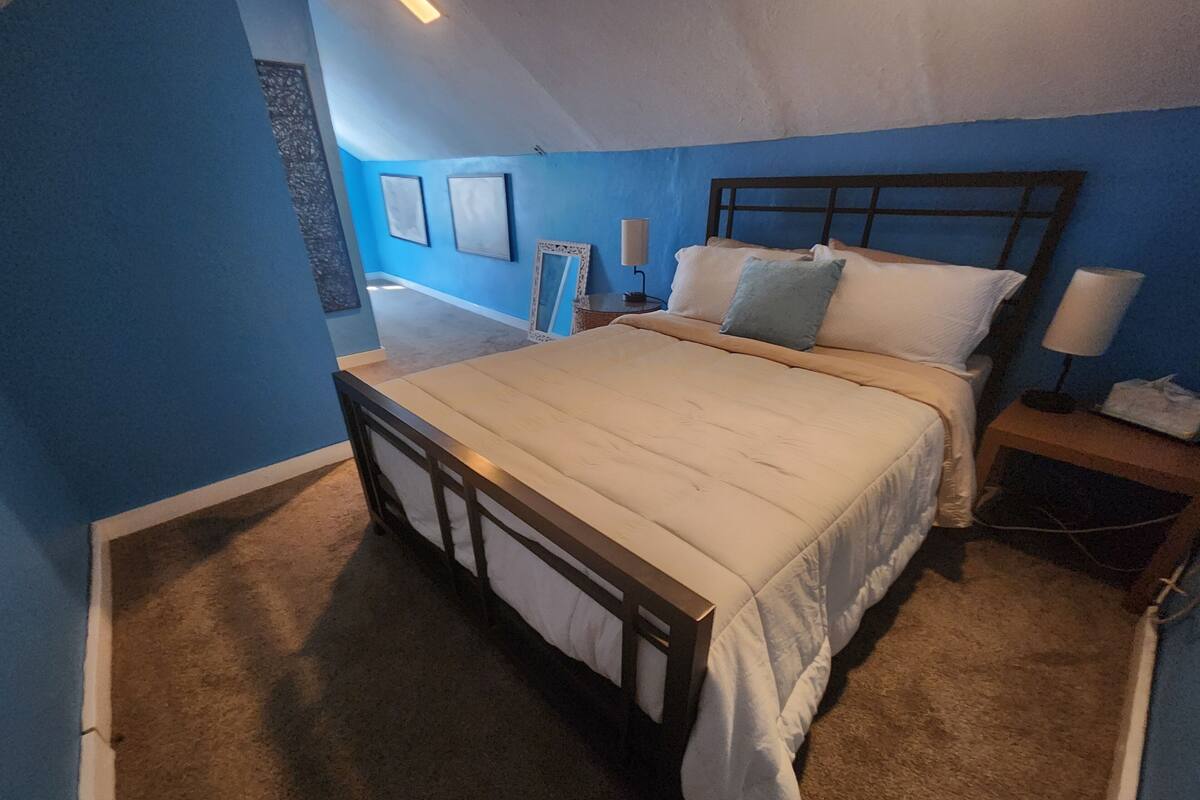 Ein Schlafzimmer mit Bett, Nachttisch und Beistelltisch.