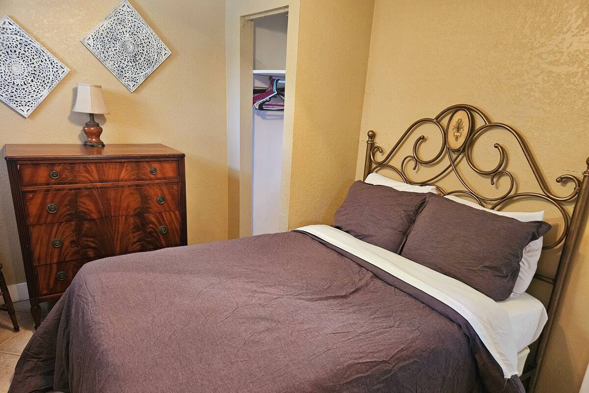 Ein Schlafzimmer mit Bett, Schminktisch und Wanddekoration.