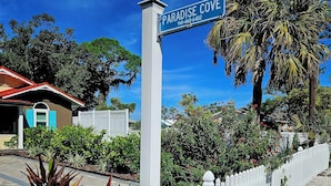 Placa de boas-vindas a Paradise Cove, indicando aluguéis de férias de luxo.